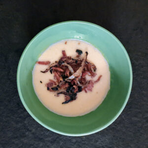 Bowl with mashed potato soup topped with bacon and crisp onion
